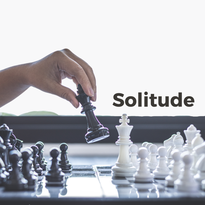 Hand moving chess piece with word Solitude