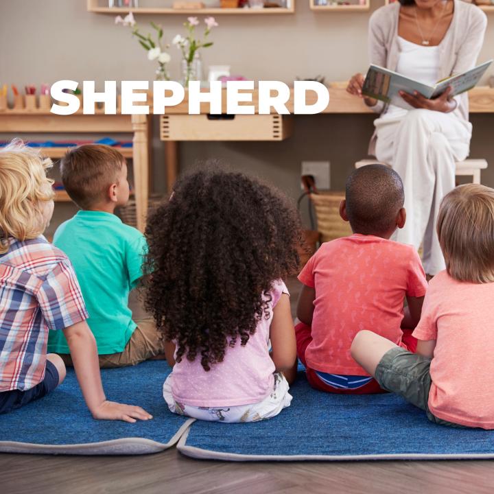 teacher reading a book to a group of students