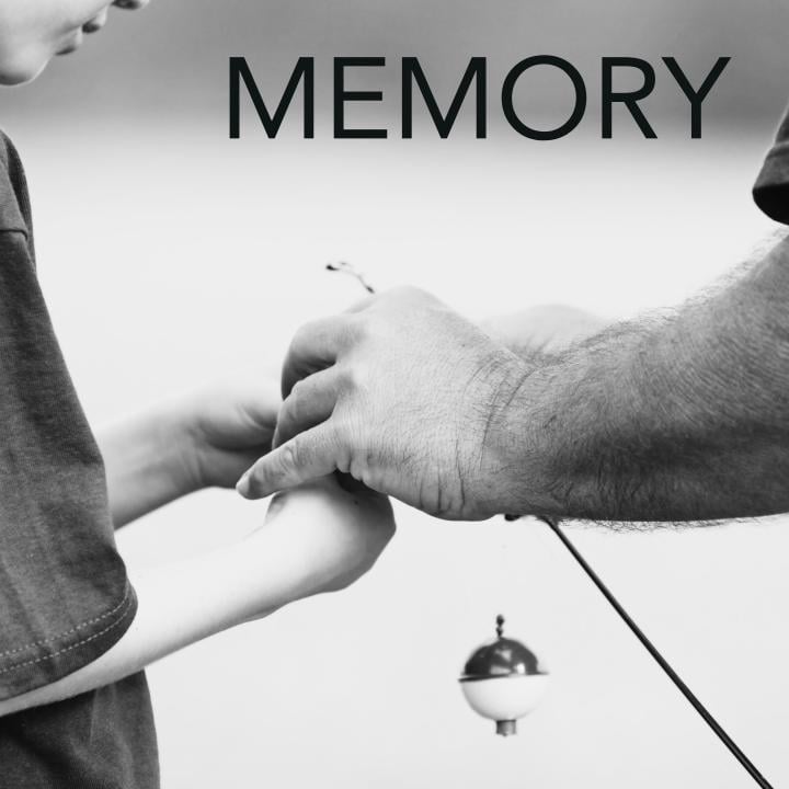 father helping his son string a fishing pole