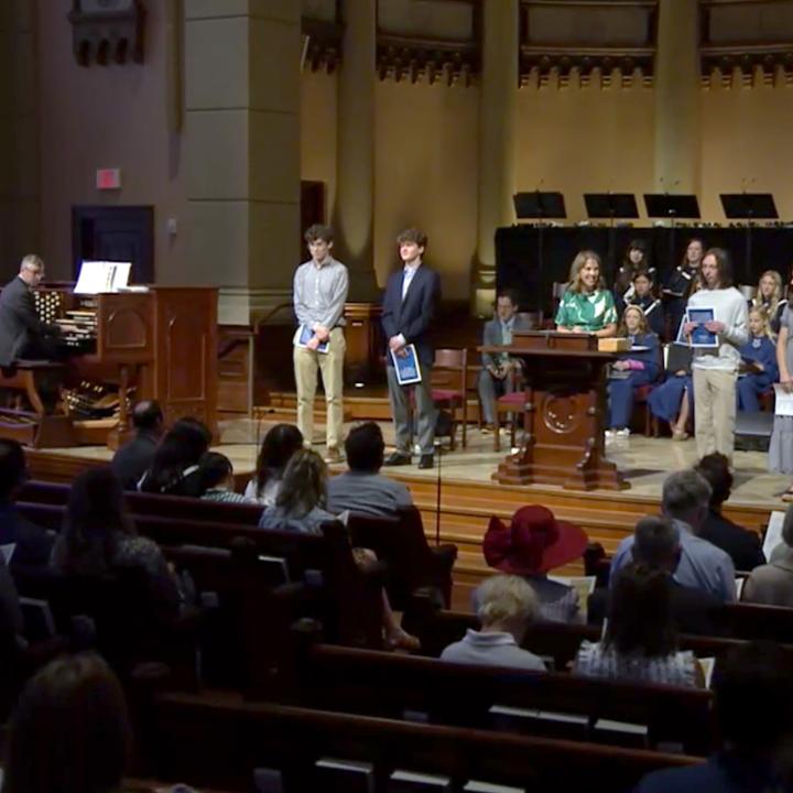 high school seniors standing on the platform in front of the congregation