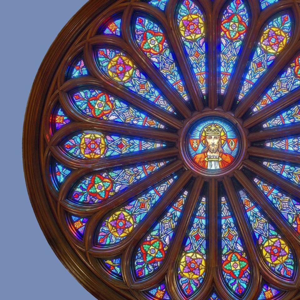 stained glass rose window with christ in the center