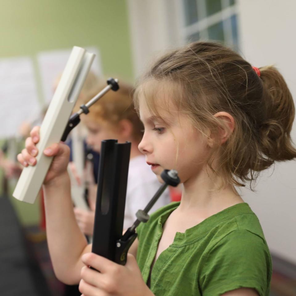 Young girl playing music instrument