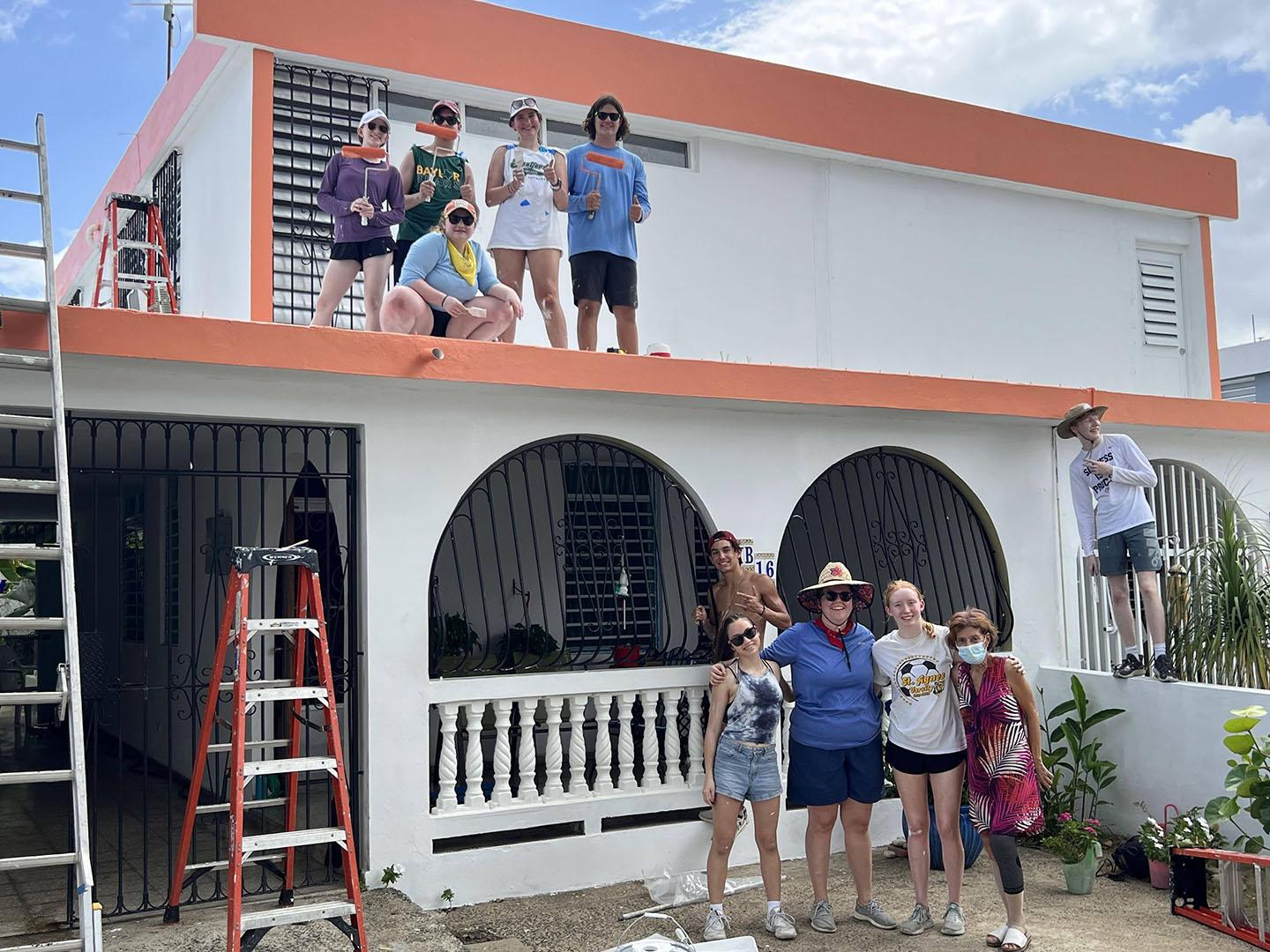 Group of volunteers standing in front of renovated house